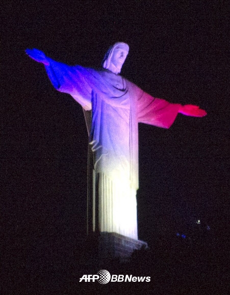14일(현지시간) 브라질 리우데자네이루에 위치한 거대 예수 그리스도상이 프랑스 혁명기념일(7월14일)을 맞이하여 프랑스 국기 색인 빨간색, 하얀색, 파랑색 빛을 받아 빛나고 있다. ⓒ AFPBBNews=News1