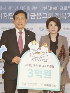 김정태(왼쪽) 하나금융그룹 회장이 지난 4월 서울 중구 을지로 본점에서 남북하나재단의 탈북 새터민 정착사업을 지원하기로 한 뒤 기부금 전달식을 가졌다.  하나금융 제공