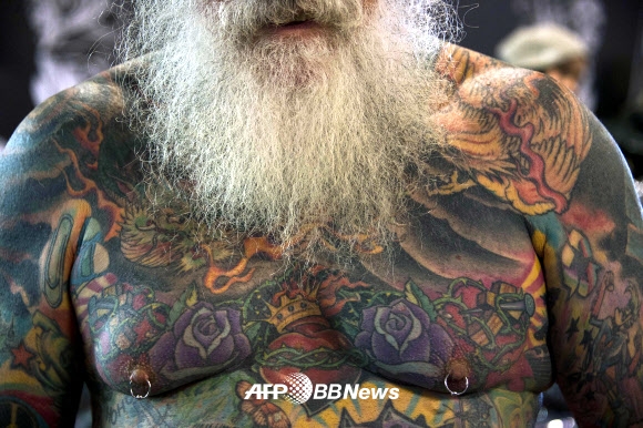 26일(현지시간) 브라질 상파울루에서 열린 ‘상파울루 타투 위크’에서 한 남성이 가슴과 팔에 가득 새겨진 타투를 보여주고 있다. ⓒ AFPBBNews=News1