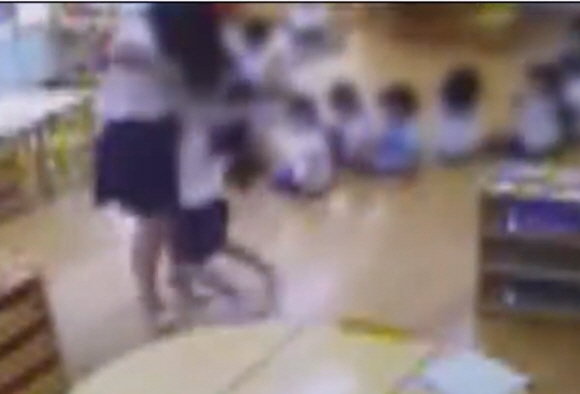 13일 공개된 폐쇄회로(CC)TV에서 경기 성남시 분당구의 한 유치원 교사가 아이를 거칠게 들었다 놓았다 하며 학대로 보이는 행동을 하고 있다.  MBC 뉴스데스크 캡처