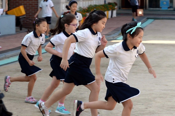 17일 여름방학을 마치고 개학한 서울 용산구 신광초등학교 학생들이 운동장을 뛰고 있다. 신광초등학교에서는 학생들이 등교시 운동장을 한바퀴 뛰는 프로그램을 시행하고 있다.  이언탁 기자 utl@seoul.co.kr