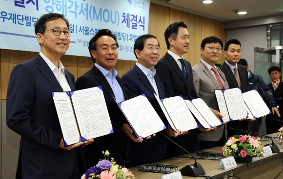 박원순(왼쪽 세 번째) 서울시장이 21일 시청에서 대우재단빌딩과 메트로타워빌딩, 서울스퀘어빌딩, 연세대 세브란스빌딩, 호텔마누 등 서울역 주변 5개 건물 대표와 서울역 고가와의 연결통로 설치 양해각서를 체결한 뒤 기념촬영하고 있다. 연합뉴스