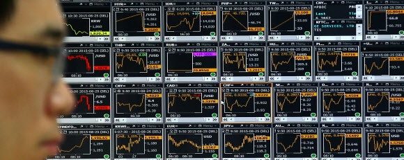 남북한 고위급 회담 타결로 군사적 긴장이 해소된 25일 오전 서울 중구 외환은행 본점 딜링룸에서 딜러들이 업무를 하고 있다. 이날 코스피는 북한 리스크 완화로 오름세로 출발했지만 중국의 증시 폭락 등의 이유로 내림세를 이어가고 있다. 연합뉴스