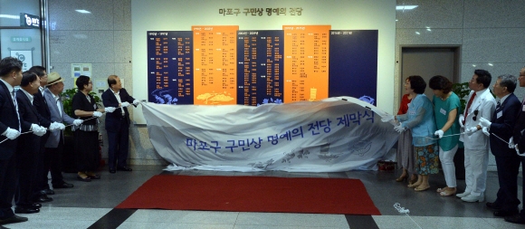 27일 박홍섭 마포구청장(좌)이 구청 1층 휴게공간 앞에서 구 발전에 기여하고, 구민의 귀감이 되는 구민상 수상자에 대한 예우와 자긍심을 고취하고자 ‘ 마포구 구민상 명예의전당’ 제막식을 하고 있다.이언탁 기자 utl@seoul.co.kr