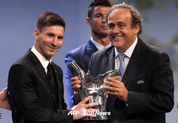 리오넬 메시(왼쪽)가 27일(현지시간) 모나코에서 열린 UEFA 2014-2015시즌 최우수선수 시상식에서 최우수선수로 선정된 후 미셸 플라티니(오른쪽) 회장으로 부터 트로피를 받고 기뻐하고 있다. ⓒ AFPBBNews=News1