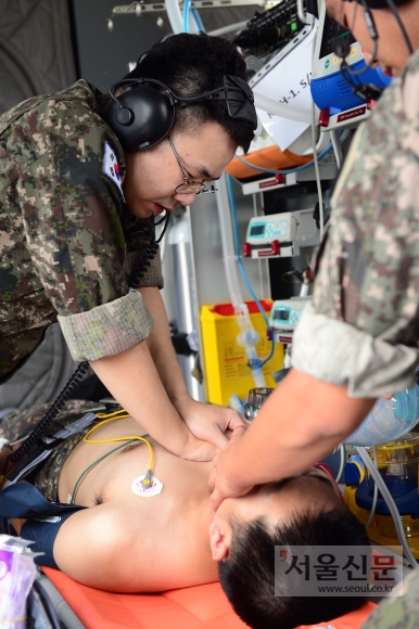 군의관이 후송 중인 환자에게 심폐소생술을 실시하고 있다.