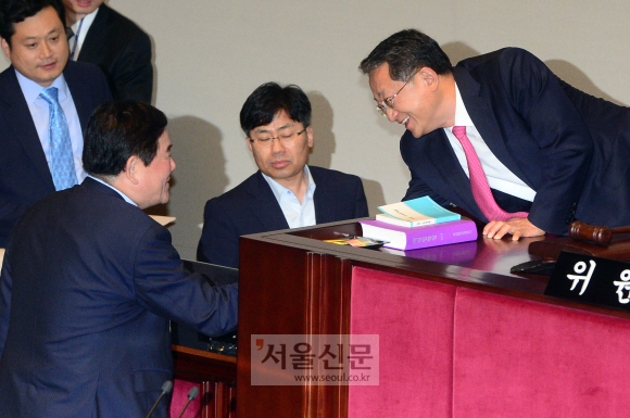 국회 예산결산특별위원장인 김재경(오른쪽) 새누리당 의원과 최경환(맨 왼쪽 옆얼굴) 경제부총리 겸 기획재정부 장관이 8일 국회에서 열린 예산결산특위 전체회의에서 2014회계연도 결산 및 예비비 지출 승인의 건이 가결된 뒤 웃으며 악수하고 있다. 정연호 기자 tpgod@seoul.co.kr