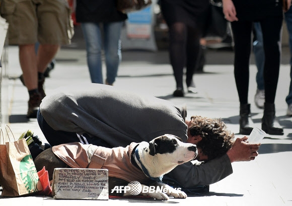 10일(현지시간) 시드니의 거리에서 한 남자가 자신의 개와 함께 구걸을 하고 있다. ⓒ AFPBBNews=News1
