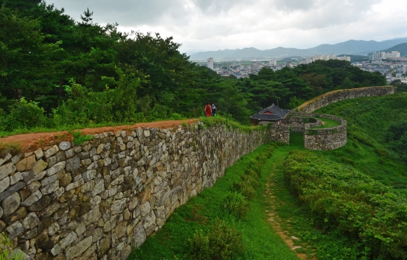 고창읍성 성벽길을 걷고 있는 주민들. 성벽 안쪽에도 고요가 깃든 숲길이 나란히 이어져 있다. 아래쪽 성문은 등양루다.