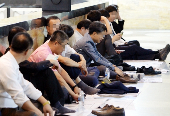 21일 국회에서 산업통상자원위원회 국정감사가 진행되는 동안 국감장 밖 복도에서 공무원들이 신발을 벗고 주저앉아 지친 모습으로 대기하고 있다. 김명국 전문기자 daunso@seoul.co.kr 