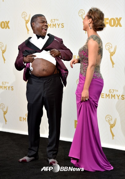 20일(현지시간) 미국 캘리포니아주 로스앤젤레스의 마이크로소프트 극장에서 열린 제67회 에미상 시상식에 참석한 영화배우이자 코미디언인 트레이시 모건(왼쪽)이 옷을 들춰 배를 내밀고 우스꽝스러운 표정을 짓고 있다. ⓒ AFPBBNews=News1