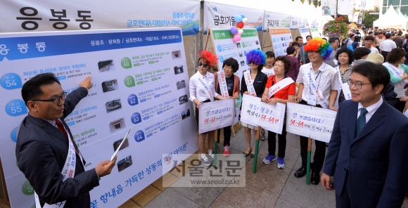 22일 정원오(오른쪽) 성동구청장이 구청 마당에서 열리고 있는 ‘2015 주민참여예산 주민 총회’에 참석해 동(洞) 사업에 대한 설명을 듣고 있다.  이언탁 기자 utl@seoul.co.kr