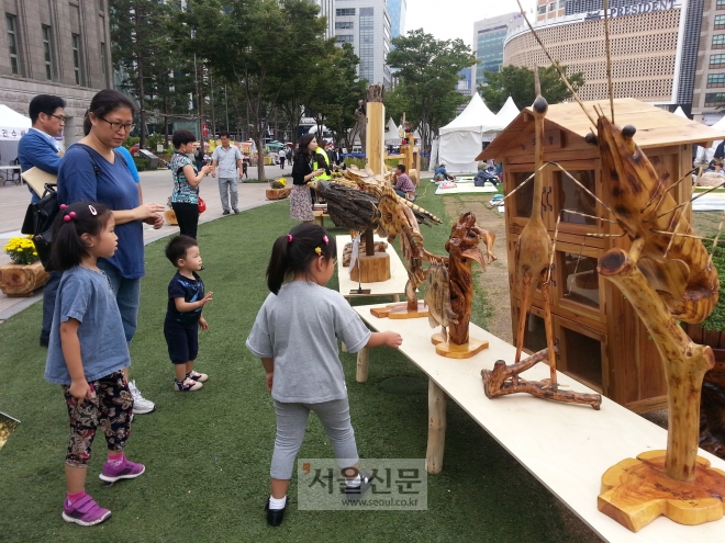 서울광장을 찾은 어린이들이 목공예품들을 신기한 듯 바라보고 있다.