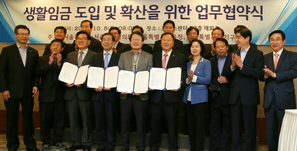 유덕열(앞줄 왼쪽에서 세 번째부터) 서울시구청장협의회장, 박원순 서울시장, 조희연 서울시교육감, 김인호 서울시의회 부의장이 8일 오전 중구 한국프레스센터에서 ‘생활임금 도입 및 확산을 위한 업무협약’을 체결한 후 협약서를 들고 기념촬영하고 있다. 연합뉴스 