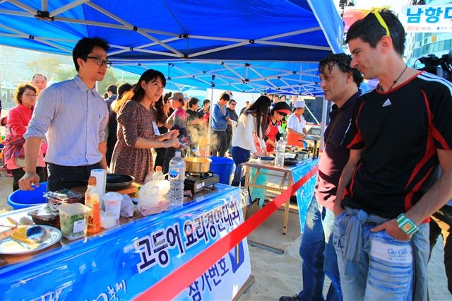 부산고등어축제 프로그램으로 열린 전국 고등어 요리경연대회에 참가한 팀이 외국인 관광객에게 요리에 대해 설명하고 있다.  부산시 제공