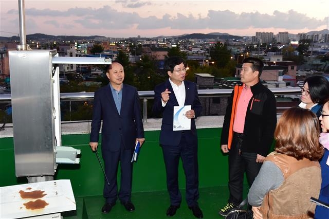 염태영(왼쪽 두 번째) 수원시장이 지난 12일 평동주민센터 옥상에서 주민들을 상대로 공군 비행장 이전 계획에 대해 설명하고 있다. 