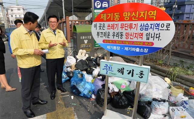 유덕열(오른쪽) 동대문구청장이 19일 ‘망신 표지판’이 세워진 정릉천 주변을 찾아 구 직원과 쓰레기 무단투기 근절 방안을 논의하고 있다. 이언탁 기자 utl@seoul.co.kr