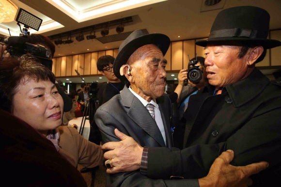 제20회차 이산가족상봉행사 1회차 상봉 첫날인 20일 오후 강원도 고성군 금강산 이산가족면회소에서 남쪽 아들 오장균이 북쪽 아버지인 오인세를 만나고 있다. 2015. 10. 20  사진공동취재단
