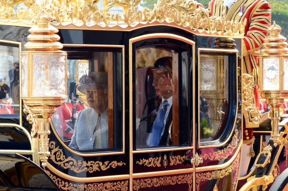 시진핑 주석이 20일 런던 중심가에서 엘리자베스 2세 여왕과 함께 왕실 전용 마차를 타고 버킹엄궁에 이르는 거리 행진에 나서고 있다. 런던 AP 연합뉴스