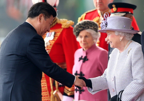 영국을 국빈 방문 중인 시진핑(왼쪽) 중국 국가주석이 첫날인 20일 런던 중심가의 ‘호스 가즈’ 광장에서 열린 공식 환영식에서 엘리자베스 2세 영국 여왕을 만나 악수를 하고 있다. 런던 AP 연합뉴스