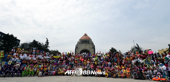21일(현지시간) 멕시코의 멕시코시티에서 열린 광대 대회에서 광대들이 혁명기념비 앞에서 단체 사진을 찍기 위해 준비하고 있다. ⓒ AFPBBNews=News1