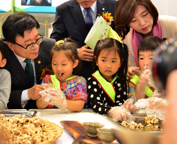 농림축산식품부는 22일 일산 킨텍스에서 제5회 2015식생활교육박람회를 개최하였다. 식생활교육박람회는 ”바른 밥상 밝은 100세”를 주제로 바른 식생활 건강한 식문화 정착을 위하여 맛보고 배우고 즐겁게 나눌 수 있는 박람회이다. 사진은 이동필(왼쪽) 농림축산식품부 장관 임경숙 대한영양사협회회장이 쌀로 만든 다양한 음식 체험관에서 아이들과 함께 쌀 강정 만들기 체험을 하고 있다.  사진제공 농림축산식품부