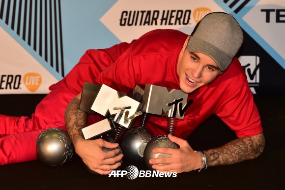 가수 저스틴 비버가 25일(현지시간) 이탈리아 밀라노에서 열린 ‘2015 MTV 유럽 뮤직 어워드’에서 트로피들과 함께 포즈를 취하고 있다. ⓒ AFPBBNews=News1