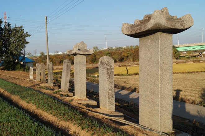 합덕제 서쪽에 늘어선 비석들. 그 뒤로 예당평야로가 지나고 있다.