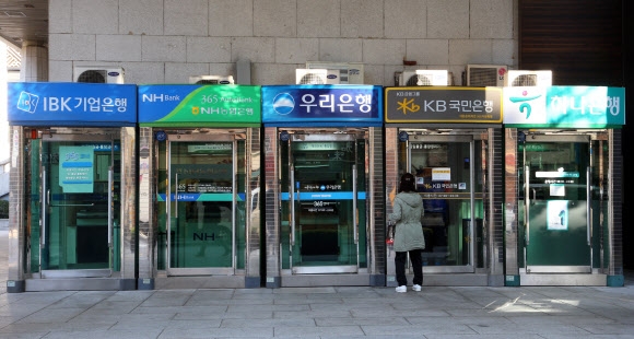 서울시내에 설치된 은행별 ATM기 앞을 시민들이 지나고 있다.  연합뉴스