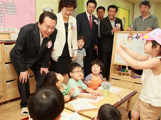 강서구 공항동 단이슬어린이집을 찾은 노현송(맨 왼쪽) 강서구청장이 아이들을 보면서 활짝 웃고 있다. 강서구 제공