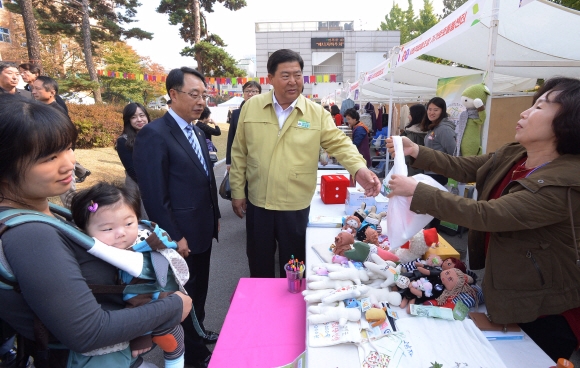 조길형(가운데) 영등포구청장이 3일 구청 광장에서 열린 사회적경제 한마당을 둘러보면서 산 봉제인형을 받으려 하고 있다. 이언탁 기자 utl@seoul.co.kr