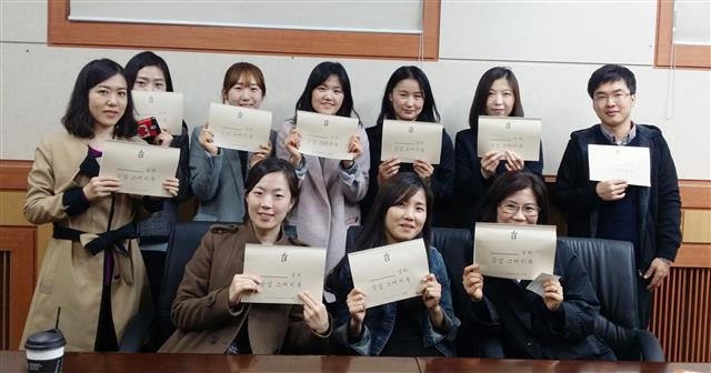 3일 종로구 신입 공무원들이 심리치료 후 자신이 완성한 컬러링북을 들고 웃고 있다. 종로구 제공