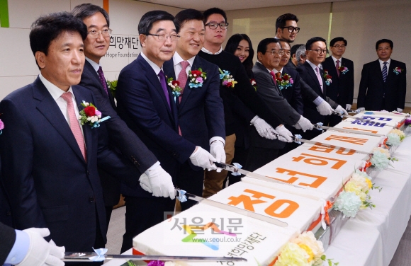 5일 서울 종로구 광화문우체국 6층 청년희망재단 사무실에서 열린 현판식에서 이기권(왼쪽 세 번째) 고용노동부 장관과 가수 효린(왼쪽 여섯 번째부터), 김대환 노사정위원장, 황철주 재단 이사장, 가수 김태우, 박현주 미래에셋회장 등 참석자들이 축하 떡을 자르고 있다. 박윤슬 기자 seul@seoul.co.kr