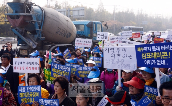 5일 성동구에 있는 삼표레미콘 공장 앞에서 삼표레미콘 공장 이전 추진위원회가 규탄대회를 갖고 폐수 방류로 한강과 중랑천을 오염시킨 것에 대해 사과하라고 촉구하고 있다. 이종원 선임기자 jongwon@seoul.co.kr