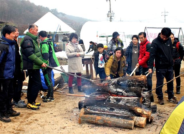 지난해 열린 첫 칠갑산 콩축제 행사장에서 방문객들이 장작불에 콩과 밤 등을 얹어 굽고 있다.  알프스마을 제공