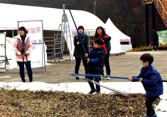 지난해 열린 첫 칠갑산 콩축제 행사장에서 방문객들이 도리깨질로 콩을 까고 있다.  알프스마을 제공
