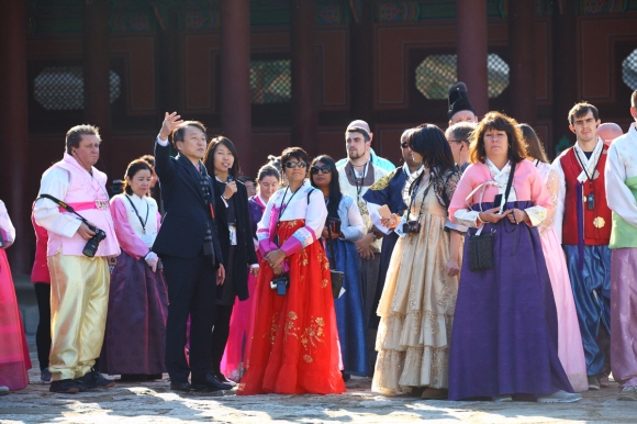 정창수(왼쪽 세 번째) 한국관광공사 사장이 12일 경복궁에서 한복을 입은 외국인 관광객을 대상으로 문화관광해설을 하고 있다.  한국관광공사 제공