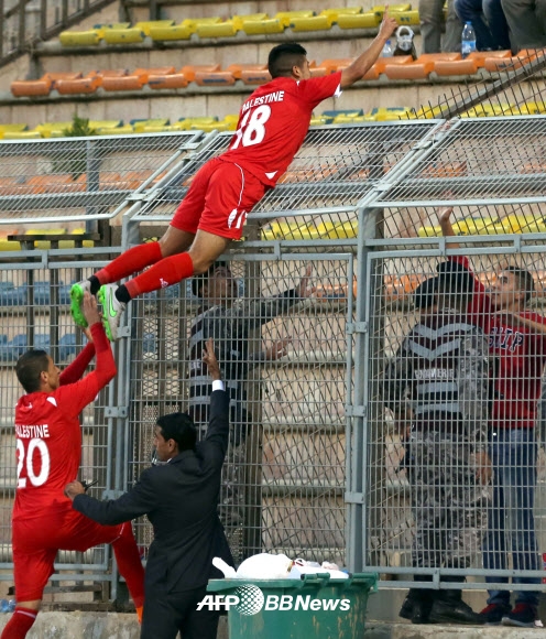 12일(현지시간) 요르단의 암만 국제 경기장에서 열린 팔레스타인과 말레이시아의 2018 러시아 월드컵 예선전에서 팔레스타인 선수가 골을 넣고 관중을 향해 세리머니를 하고 있다. ⓒ AFPBBNews=News1
