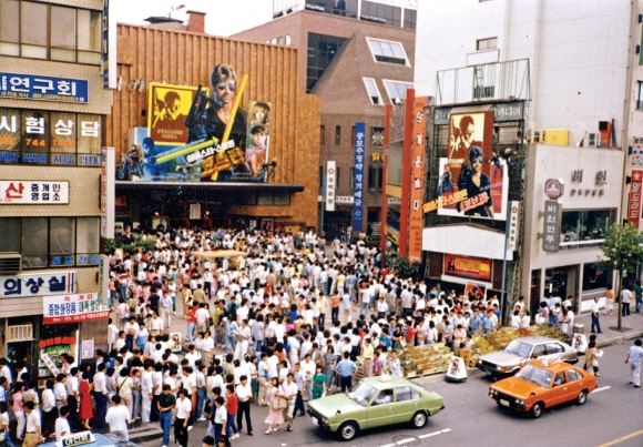 실베스터 스탤론 주연의 할리우드 영화 ‘코브라’를 보러 몰려든 사람들로 북새통을 이루고 있는 서울 종로3가 피카디리 극장 앞 모습. 6·10항쟁과 6·29선언으로 이어지는 민주화의 격랑으로 그 어느 해보다 뜨거웠던 1987년 여름 스마트폰은커녕 인터넷도 몰랐던 우리 젊음들에게 영화는 곤고한 일상을 달랠 거의 유일한 즐거움이었다. 서울신문 포토라이브러리