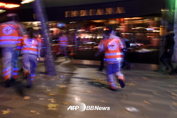 파리 연쇄 테러 현장에 구급대원들이 달려가고 있다. ⓒ AFPBBNews=News1