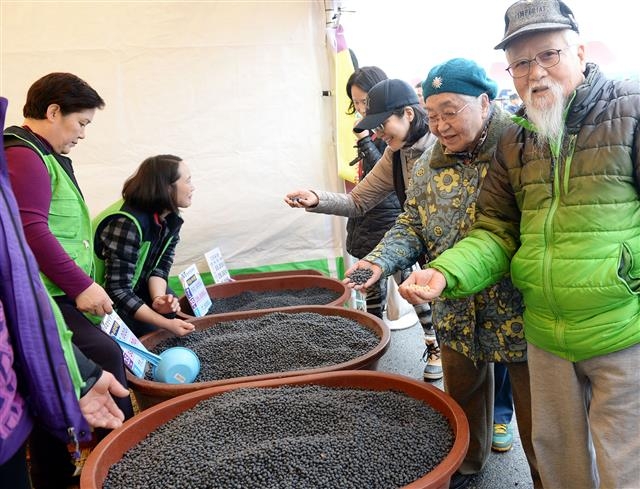 관광객들이 주민들이 파는 서리태콩을 둘러보고 있다.