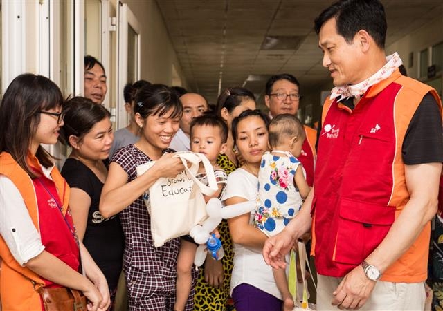 지난 11~18일 베트남 타인호아 아동병원에서 열린 ‘제20회 베트남 얼굴 기형 어린이 무료 수술’ 행사에서 이문석(맨 오른쪽) SK사회공헌위원회 위원장이 수술을 기다리는 어린이와 부모들에게 에코백에 학용품을 담은 ‘드림패키지’를 나눠 주고 있다. SK그룹 제공