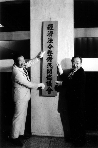 고인(왼쪽)이 1985년 경제법령 정비 민간협의회 설립 때 간판을 달고 있다.  전국경제인연합회 제공