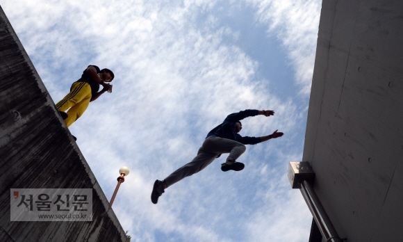 건너편 건물로 뛰어넘기 위해 점프한 학생이 마치 하늘을 나는 것처럼 보인다.