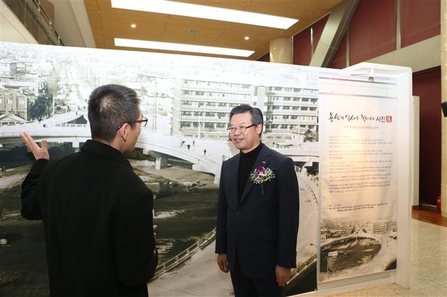 성장현(오른쪽) 용산구청장이 8일 용산아트홀에서 열린 ‘용산의 역사를 찾아서’ 사진전에서 향토사학자 김천수씨와 1967년 삼각지 모습의 사진을 보며 이야기를 나누고 있다.