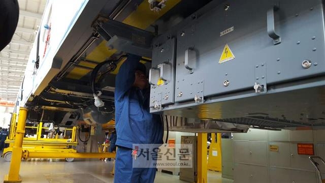 한 직원이 허셰 아래로 들어가 조립 상태를 살펴보고 있다.