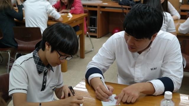 지난 6월 진행된 씨드스쿨 프로그램에서 덕양중학교 학생이 대학생 멘토(오른쪽)의 도움으로 자신의 꿈을 설계하고 있다. 대한민국교육봉사단 제공