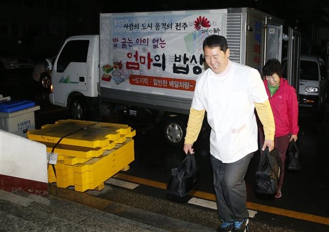 김승수 전주시장이 지난해 취임하자마자 처음 결재한 ‘엄마의 밥상’ 사업에 참여한 전북외식산업 강철 사장이 영양사이자 부인인 이문화씨와 함께 결식아동에게 따듯한 아침밥을 배달하고 있다.  전주시 제공 