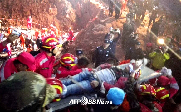 중국 선전 공단 부근에서 발생한 산사태 현장에서 23일(현지시간) 19세 소년이 67시간 만에 구조되어 들것에 실려 나오고 있다. ⓒ AFPBBNews=News1