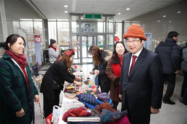 이동진(오른쪽) 도봉구청장이 지난 18일 도봉구청 1층 로비에서 열린 수제Bee 프리마켓을 찾아 판매중인 털모자를 써 보고 있다. 도봉구 제공